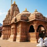 Govind Dev Ji Temple in Jaipur with traditional sandstone architecture and devotees in the courtyard.