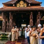 Guruvayur Temple in Kerala showing traditional architecture and devotees at the entrance.