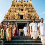 Golden gopuram of Kanchi Kamakshi Temple with devotees at the entrance.