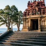 Hilltop Dravidian-style temple of Lord Murugan at Kundrathur with stone architecture and steps leading upward.