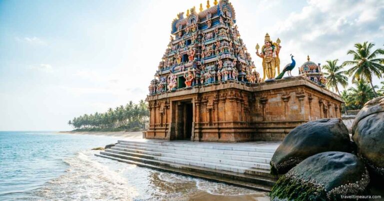 Coastal Hindu temple with tall gopuram towers beside the sea.