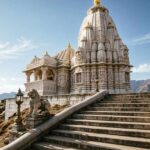 White hilltop Hindu temple of Babulnath Temple with steps leading up.