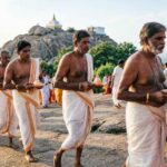 Pilgrims walking barefoot around Arunachala Hill during Giri Pradakshina.